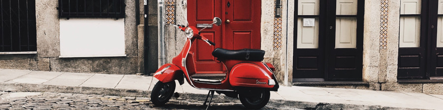 Vespa rouge dans une ruelle en Italie