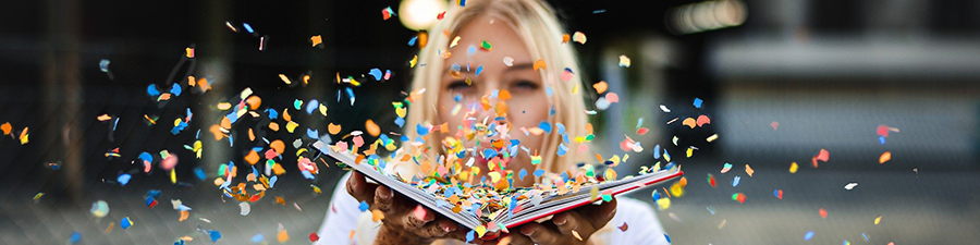 Une femme souffle sur des confettis dans un livre